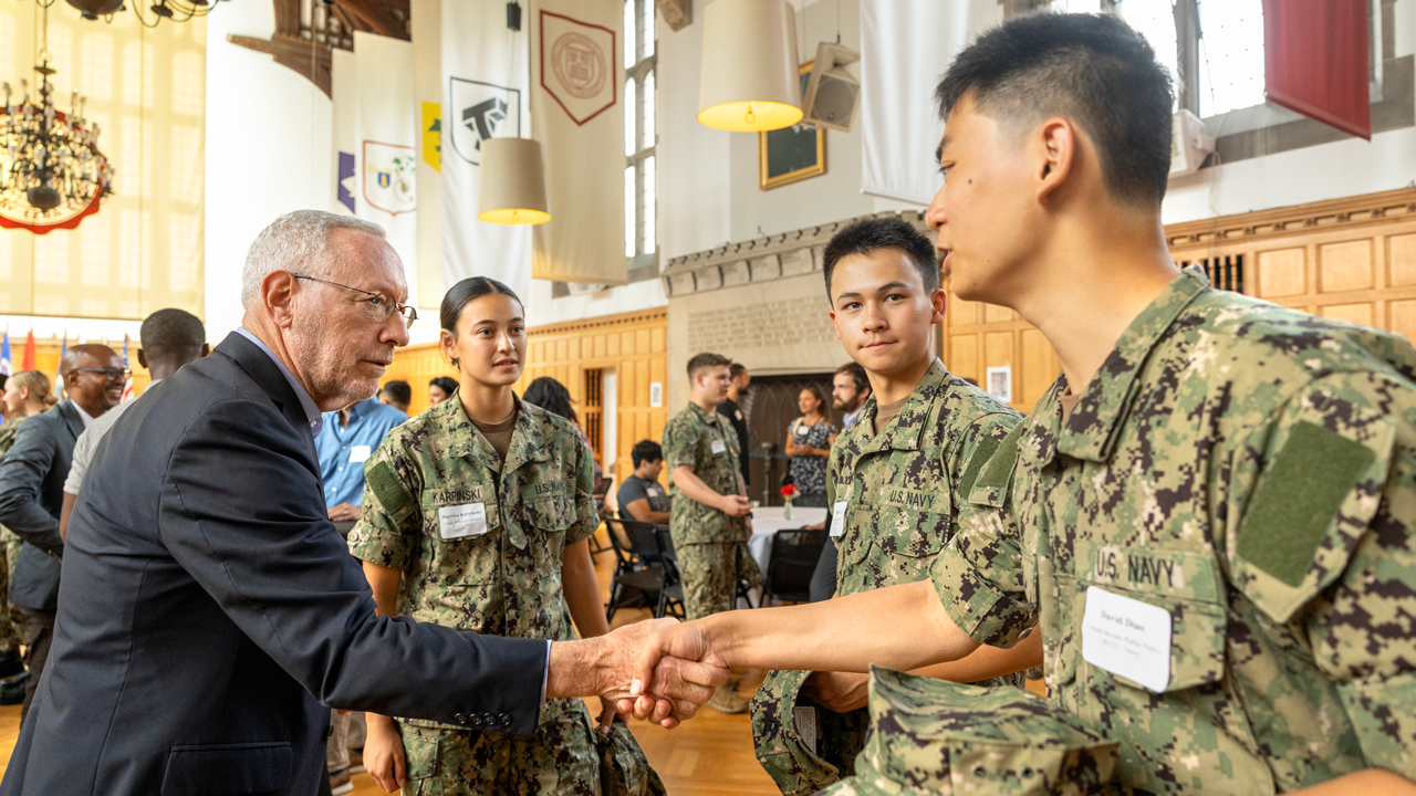 Provost Michael I. Kotlikoff greets Midshipman David Diao ’27, as Midshipman Marris Karpinski and Midshipman Nathan Li ’27 look on