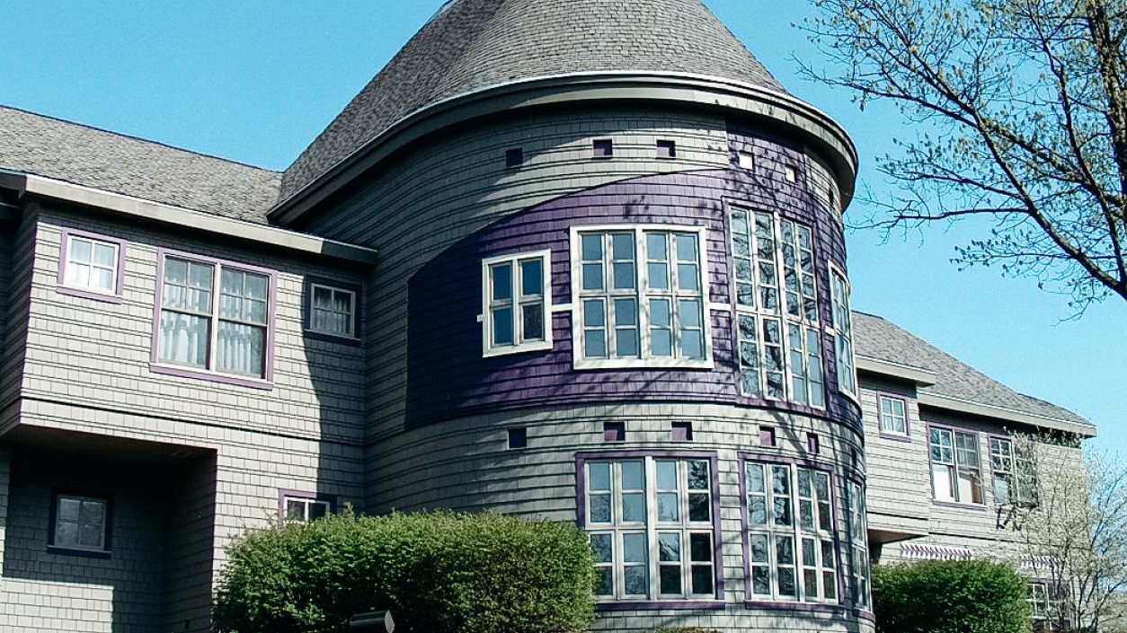 A purple Hiawatha belt painted on the second story of the grey house.