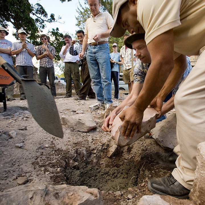 People digging and removing stones from a hole in the ground