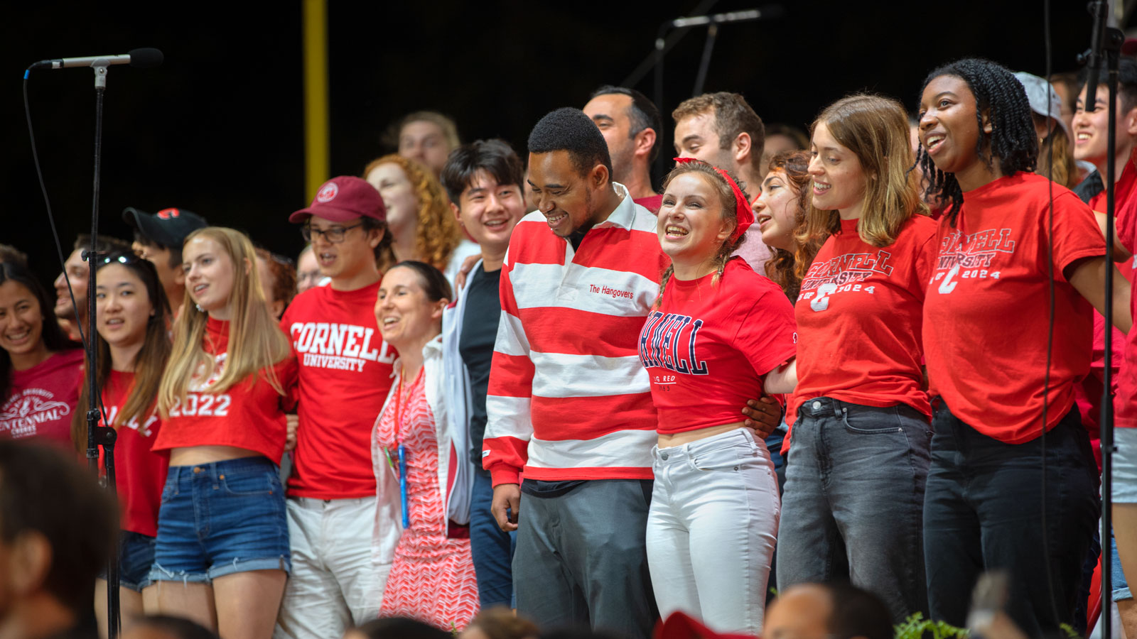 Students arm-in-arm singing the Cornell alma mater.