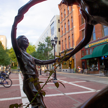 Sculpture of dancing mother and child on the Ithaca Commons
