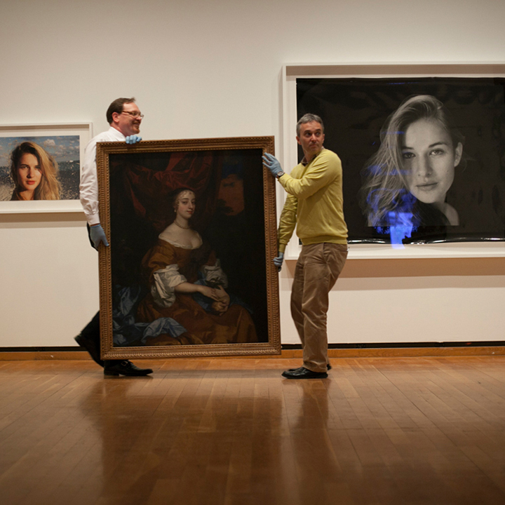 Two men moving a piece of art