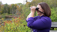 woman holding binoculars to her eyes