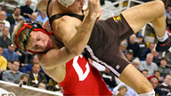 one male wrestler throwing another to the ground